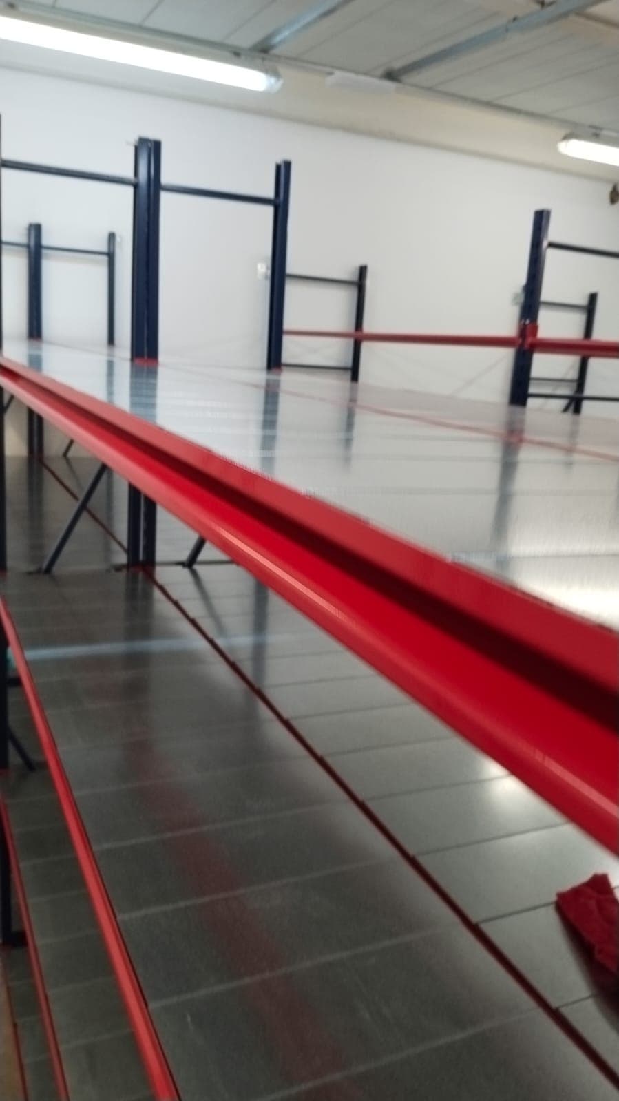Pasillo entre estanterías de un almacén ya vacío y limpio
