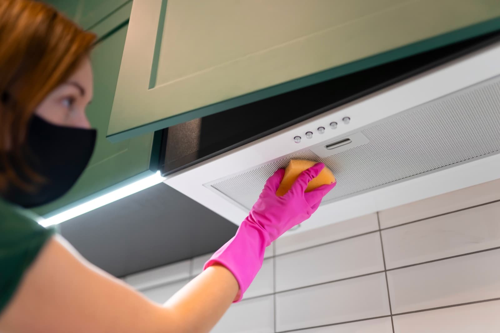 Limpieza de la campana de una cocina con guantes