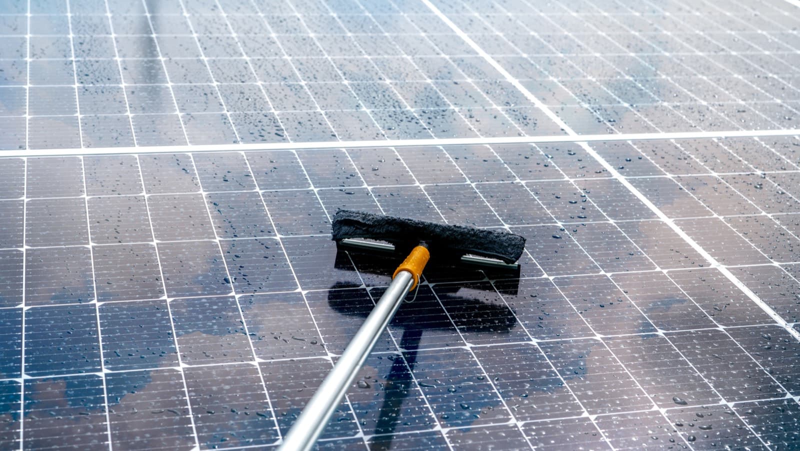 Aclarado de placas solares con agua y mopa de silicona