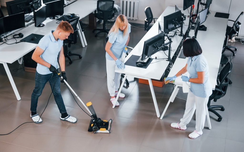 Cleans floor. Group of workers clean modern office together at daytime quienes somos
