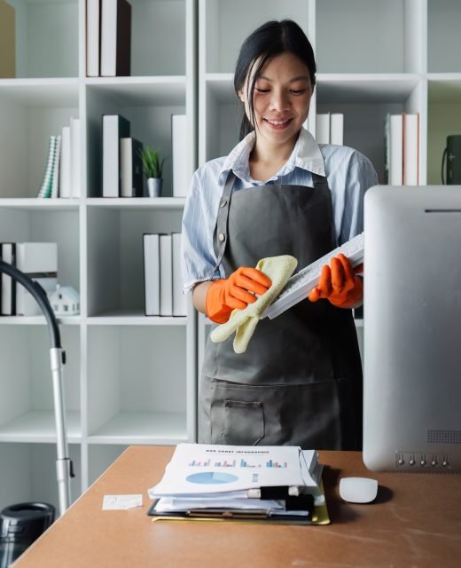 Female housekeeper smile and wearing glove, preparing to clean office Equipo profesional de limpieza en Mataró realizando servicios a domicilio